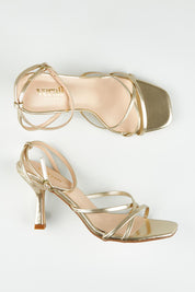 A model wearing size 37 of the Penelope Heel in colour Champagne (Metallics), from the front, showing the whole outfit