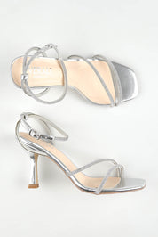 A model wearing size 37 of the Pepper Heel in colour Silver (Metallics), from the front, showing the whole outfit