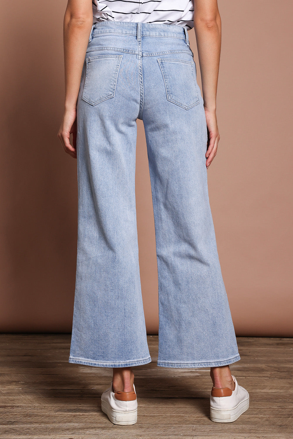 Model Madeline wearing size 9 of the Jane Highin colourWaisted Wide Leg Jean - Lightdenim (Blue), from the back