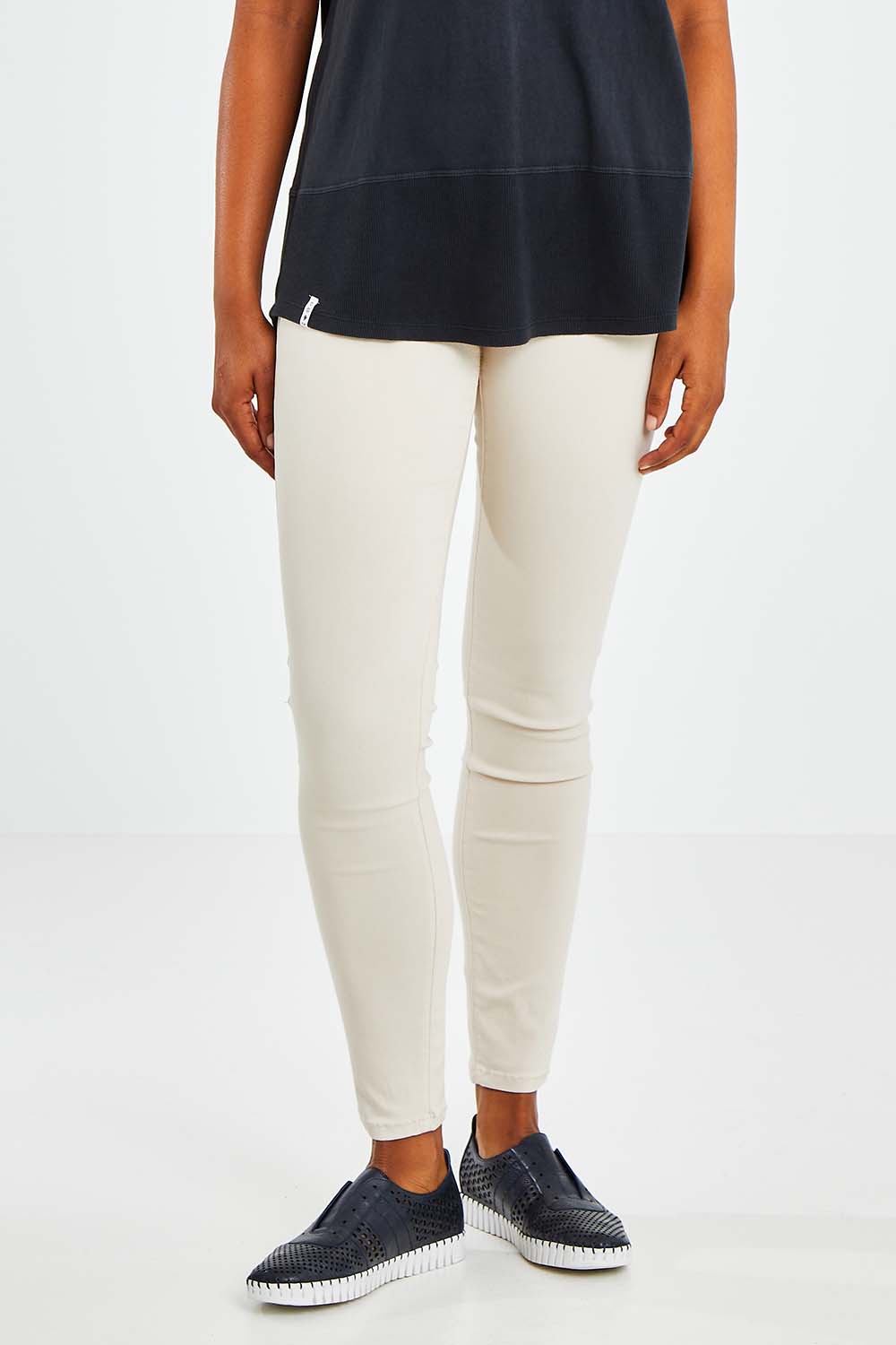 Model Olivia wearing size 10 of the Raven Skinny in colour Cream (White), from the front, cropped image