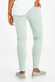 Model Olivia wearing size 10 of the Raven Skinny in colour Green (Green), from the back