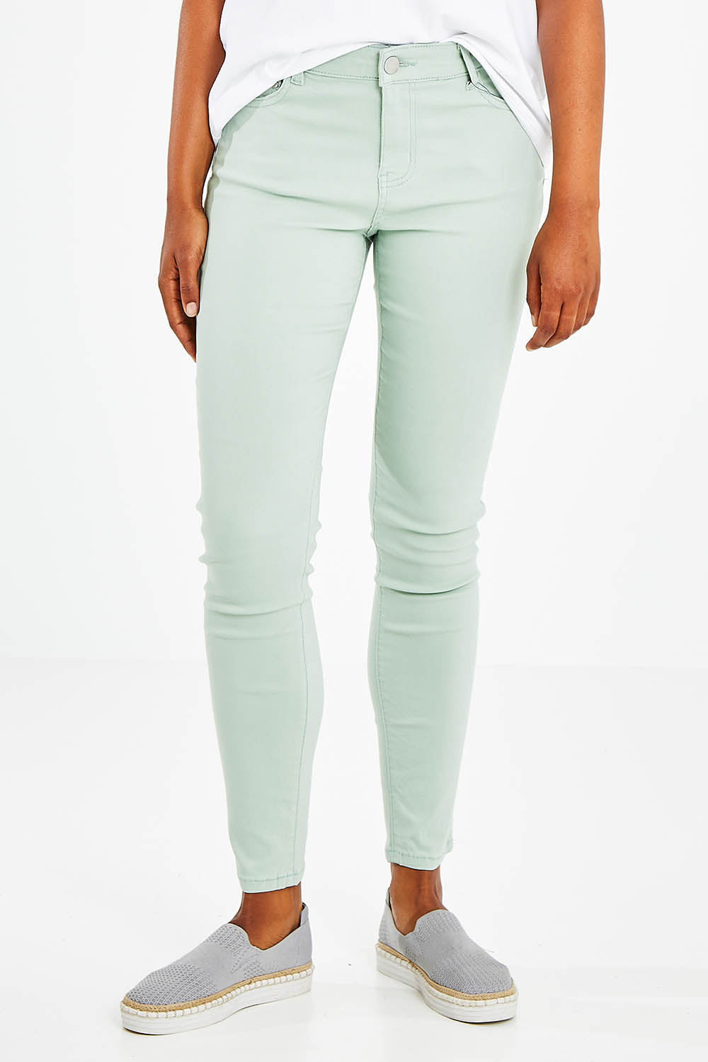 Model Olivia wearing size 10 of the Raven Skinny in colour Green (Green), from the front, cropped image