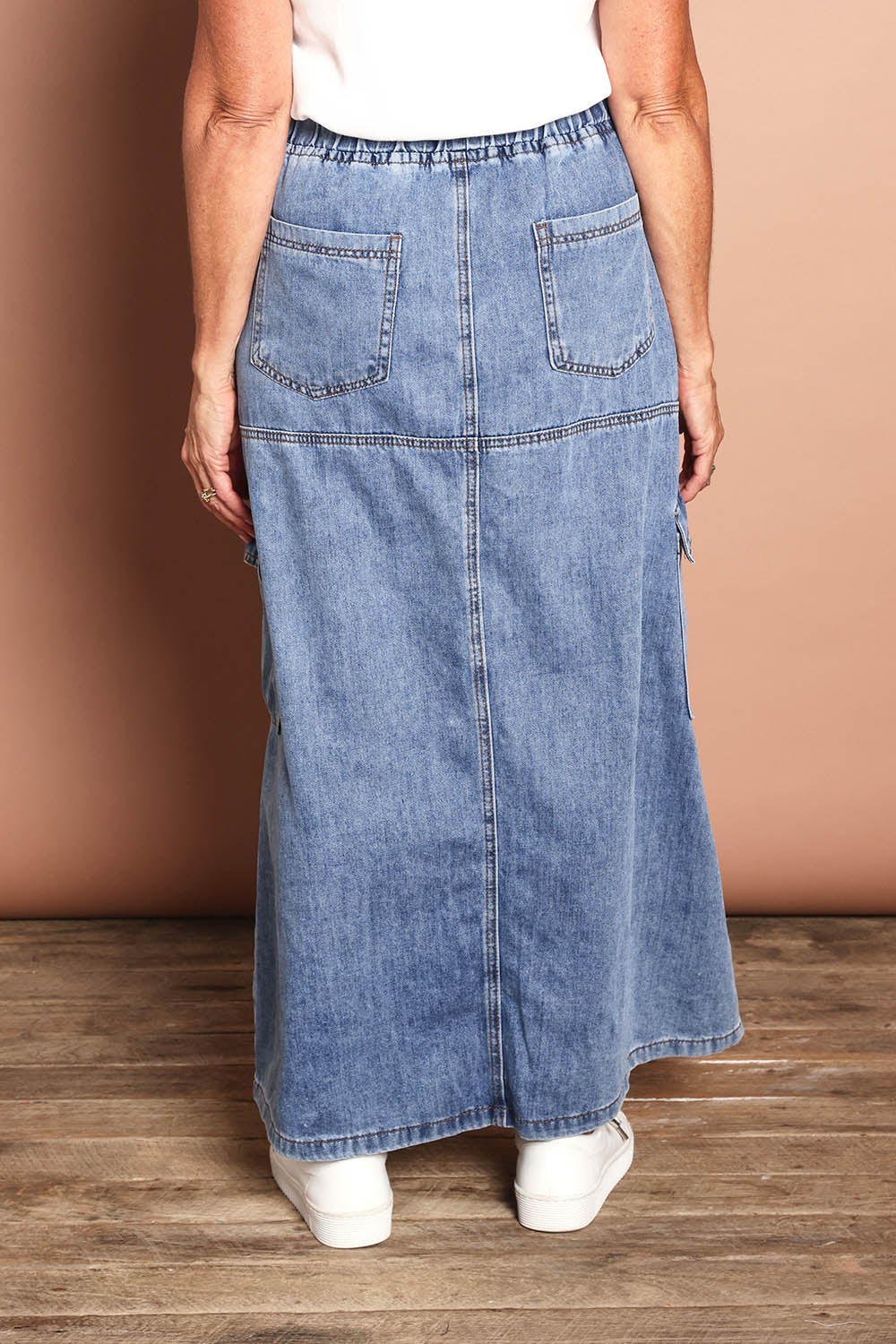 Model Sandy wearing size 10 of the Millie Pull On Denim Skirt in colour Denim (Blue), from the back
