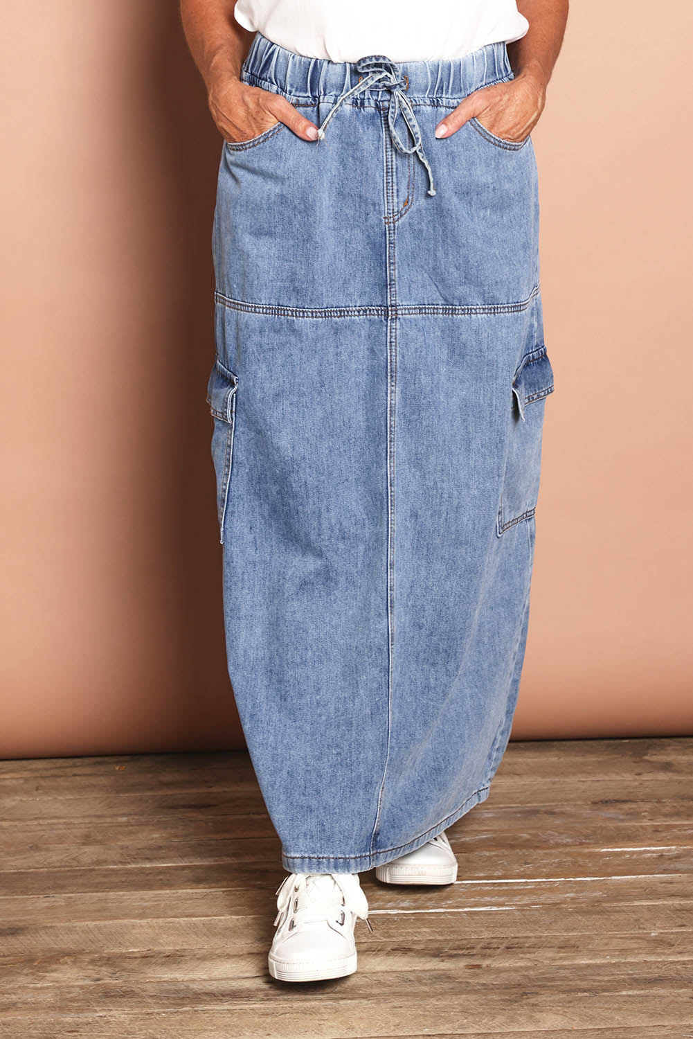 Model Sandy wearing size 10 of the Millie Pull On Denim Skirt in colour Denim (Blue), from the front, cropped image