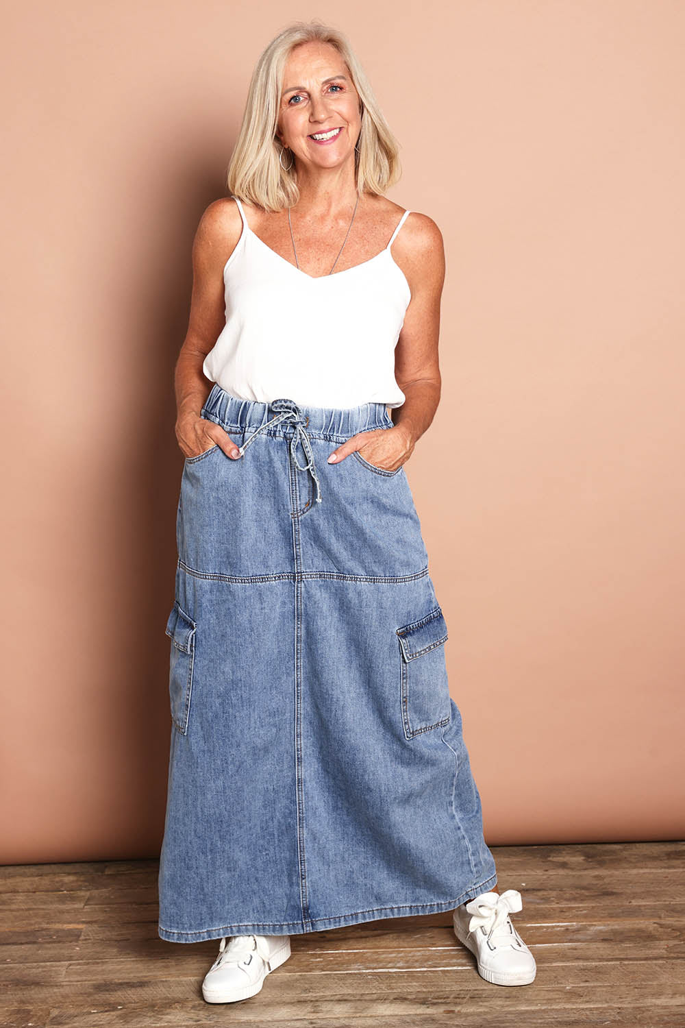 Model Sandy wearing size 10 of the Millie Pull On Denim Skirt in colour Denim (Blue), from the front, showing the whole outfit