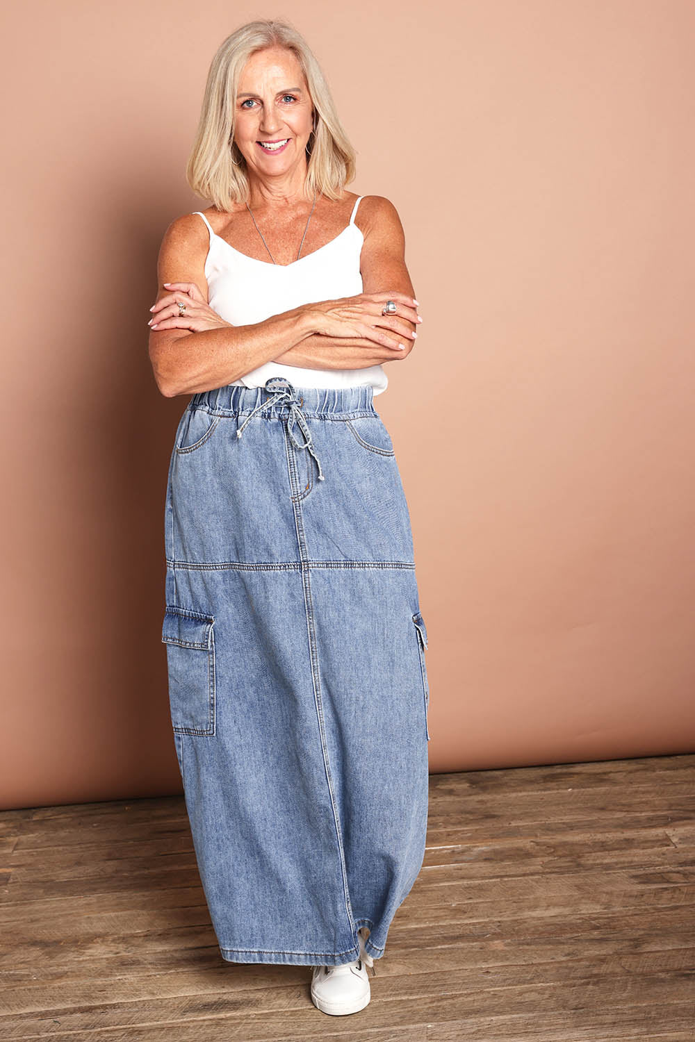 Model Sandy wearing size 10 of the Millie Pull On Denim Skirt in colour Denim (Blue), from the front, showing the whole outfit