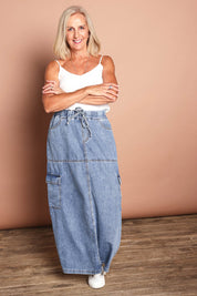 Model Sandy wearing size 10 of the Millie Pull On Denim Skirt in colour Denim (Blue), from the front, showing the whole outfit