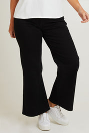 Model Laura wearing size 14 of the Candice Wide Leg Jean in colour Black (Blue), from the front, cropped image