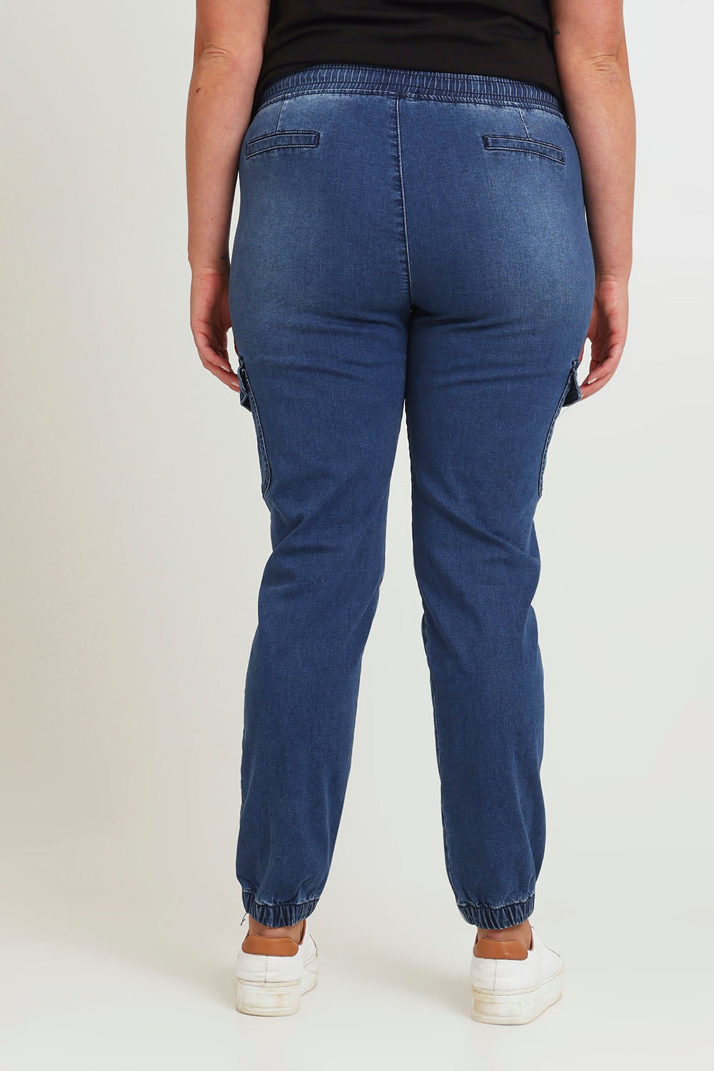 Model Chanel wearing size 16 of the Harlow Cargo Jogger in colour Darkdenim (Blue), from the back