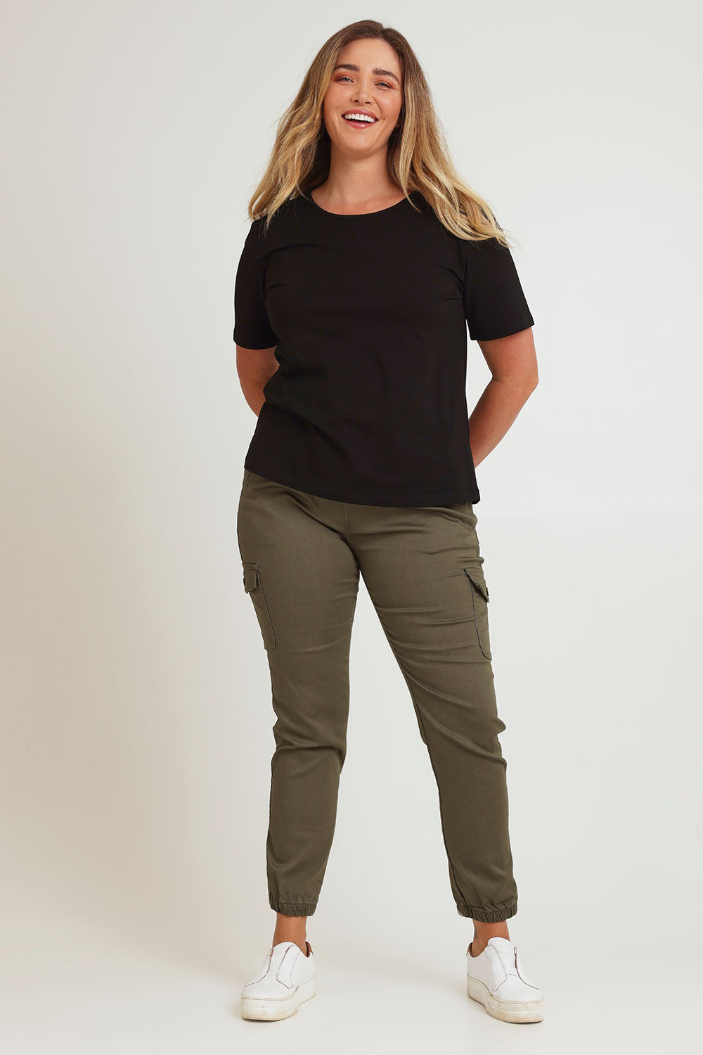 Model Chanel wearing size 16 of the Harlow Cargo Jogger in colour Khaki (Green), from the front, showing the whole outfit