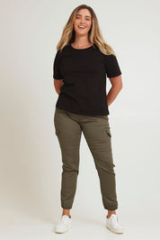 Model Chanel wearing size 16 of the Harlow Cargo Jogger in colour Khaki (Green), from the front, showing the whole outfit