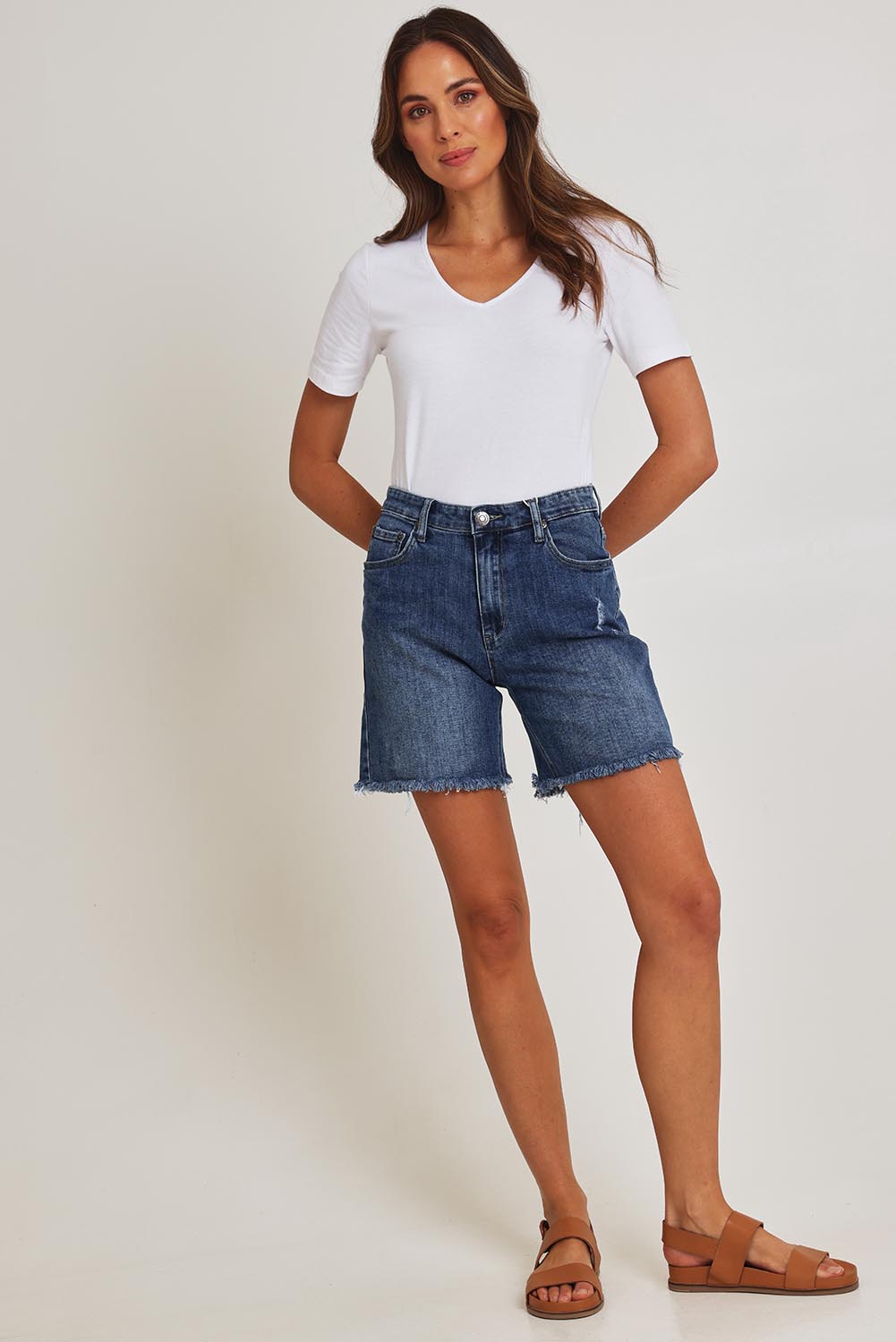 Model Madeline wearing size 10 of the Kerrie Frayed Hem Shorts in colour Dkdenim (Blue), from the front, showing the whole outfit