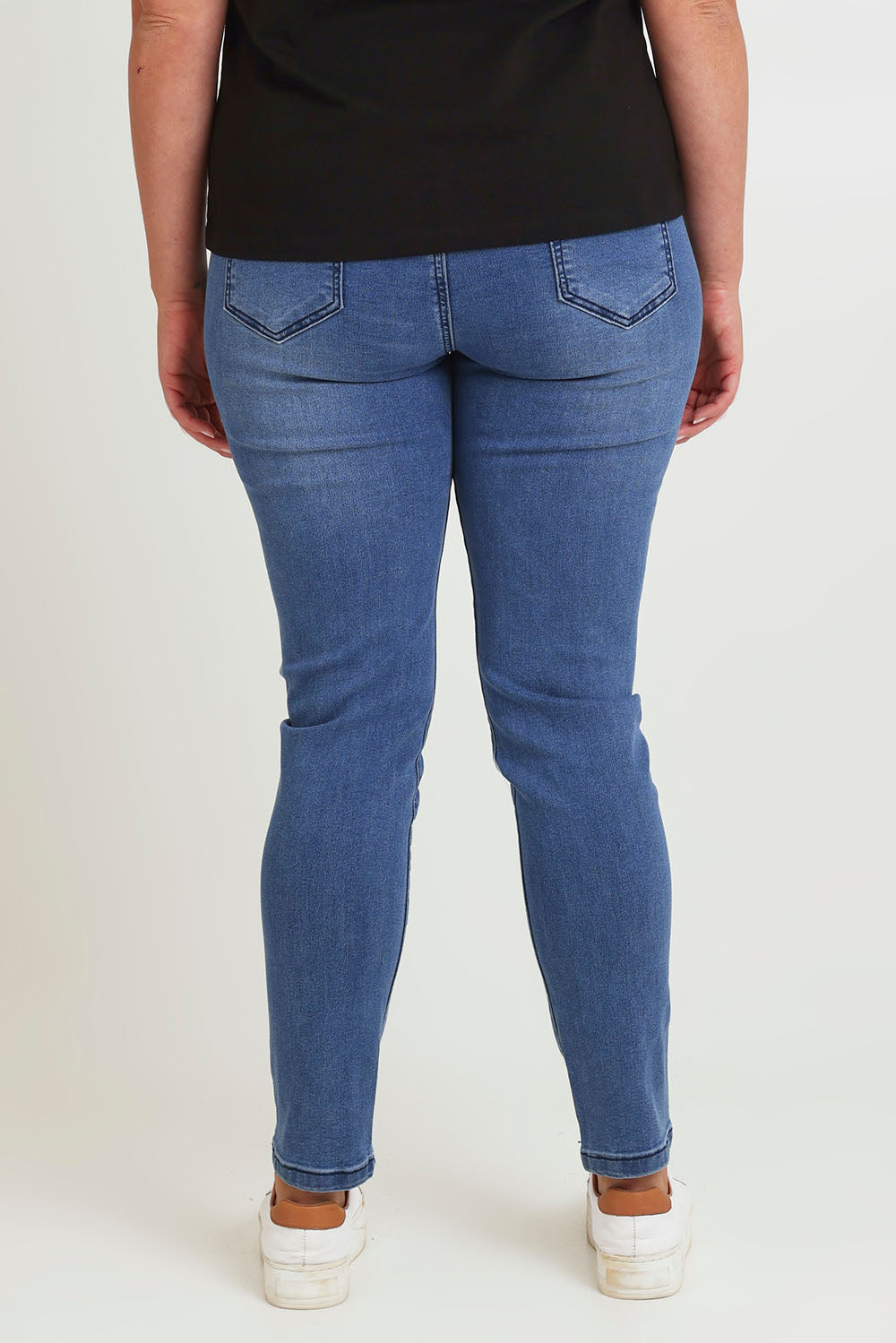 Model Chanel wearing size 16 of the Paige Pull On Jean in colour Midblue (Blue), from the back