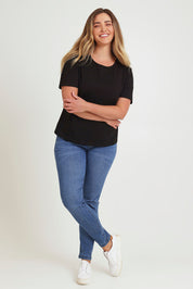 Model Chanel wearing size 16 of the Paige Pull On Jean in colour Midblue (Blue), from the front, showing the whole outfit