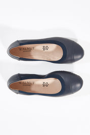 A model wearing size 37 of the Ava Leather Flat in colour Navy (Blue), from the front, showing the whole outfit
