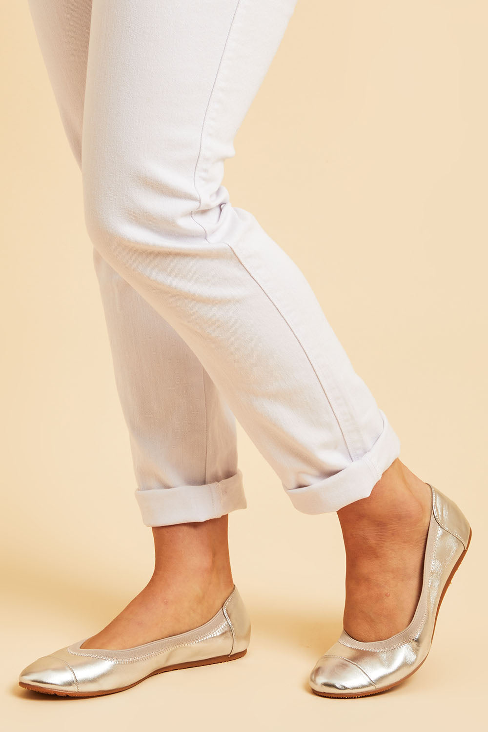 A model wearing size 38 of the Ava Leather Flat in colour Silver (Metallics), from the front, cropped image