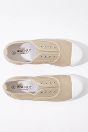 A model wearing size 37 of the Euro Elastic Plimsole in colour Sand, from the front, showing the whole outfit