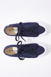 A model wearing size 37 of the Empire Canvas Sneaker in colour Navy (Blue), from the front, showing the whole outfit