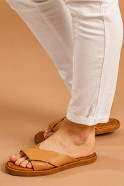 A model wearing size 38 of the Lauren Leather Slide in colour Coconuttan, from the front, cropped image