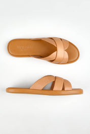 A model wearing size 37 of the Lola Leather Slide in colour Cocotan (White), from the front, showing the whole outfit