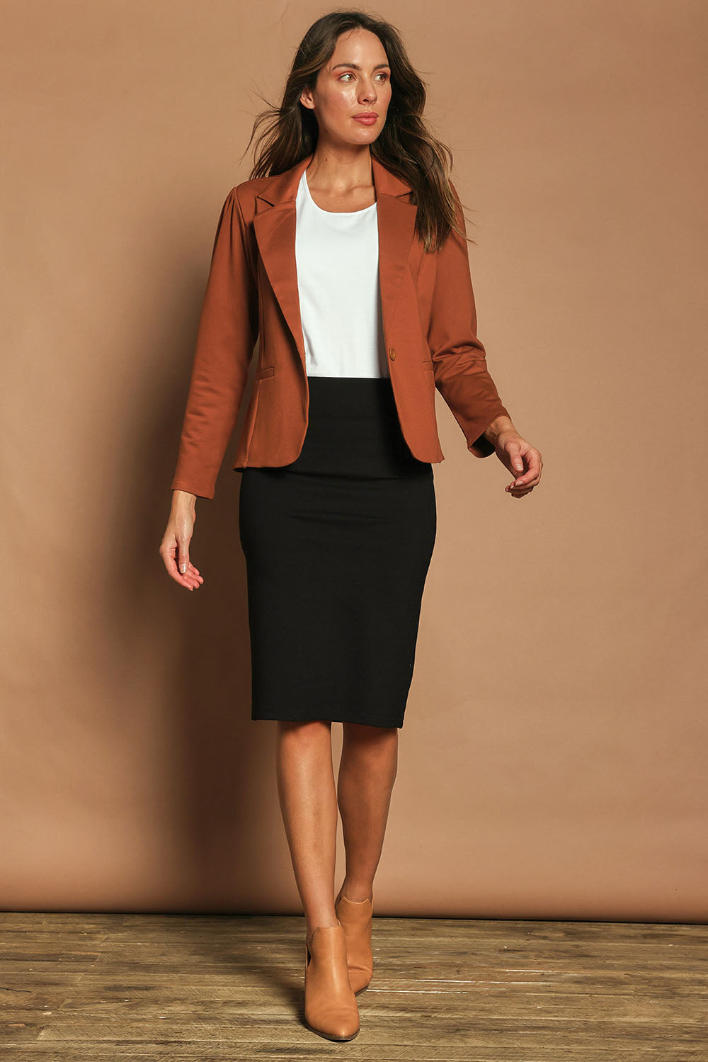 Model Madeline wearing size 10 of The Ponte Knee Length Pencil Skirt in colour Black (Black), from the front, showing the whole outfit