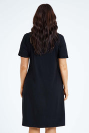 Model Laura wearing size L of the Short Sleeve Vin colourNeck Bamboo Dress - Black (Black), from the back