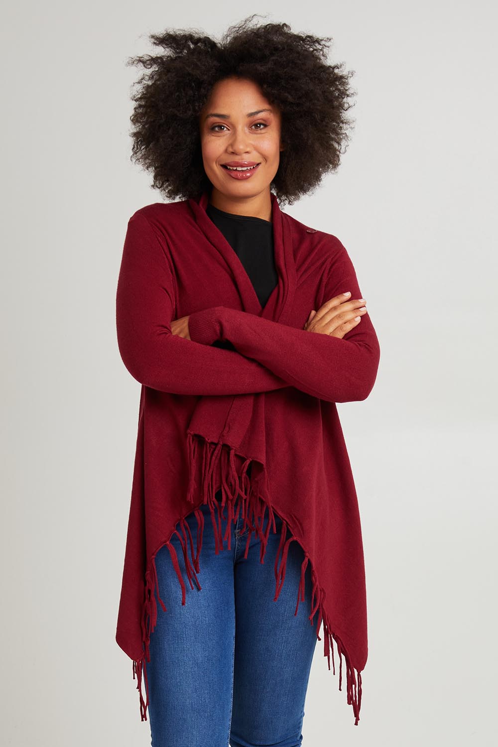 Model Olivia wearing size S of the Long Sleeve Knit Poncho in colour Burgundy (Red), from the front, cropped image