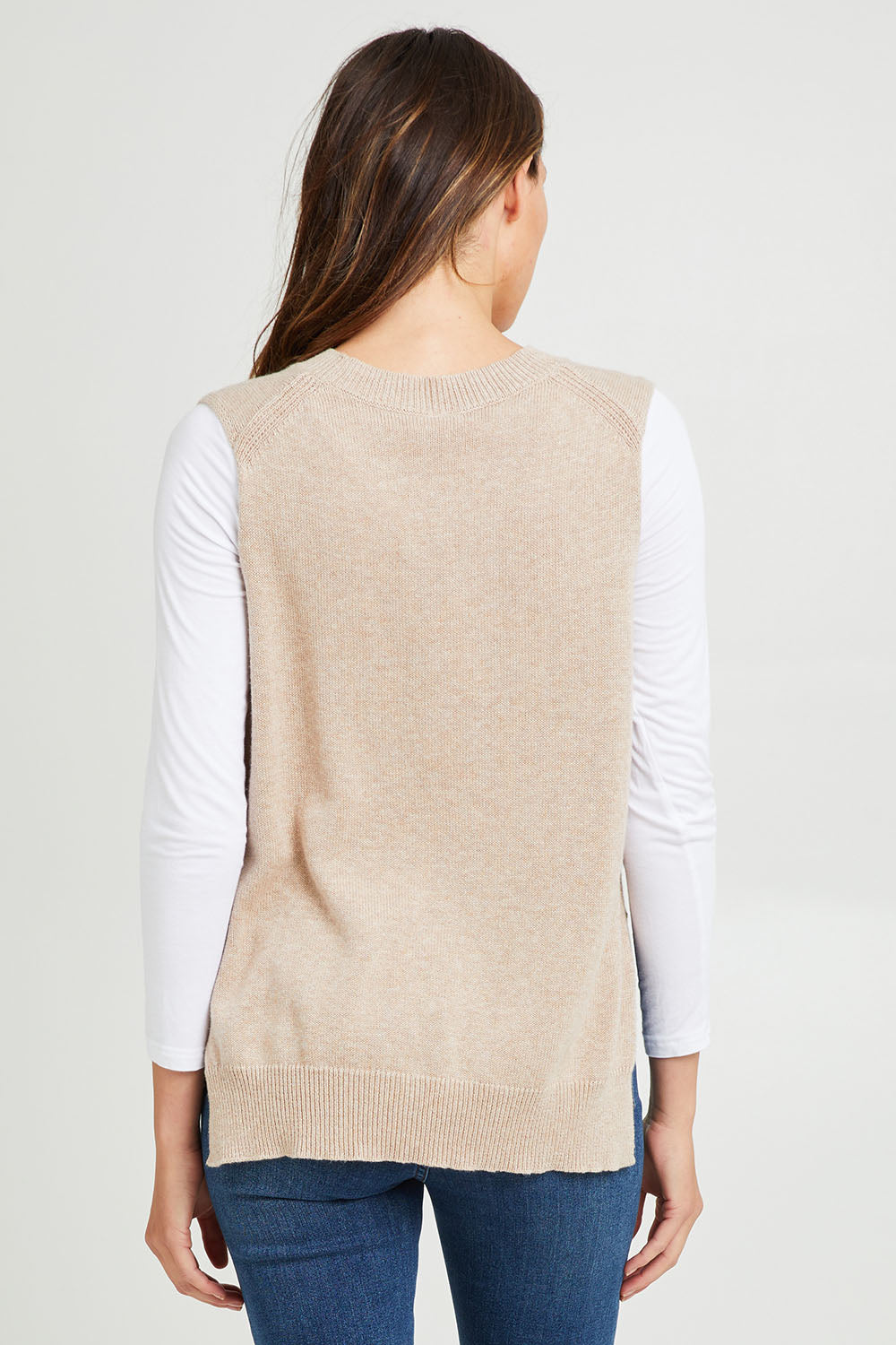 Model Madeline wearing size S of the Essential Vest in colour Oat, from the back