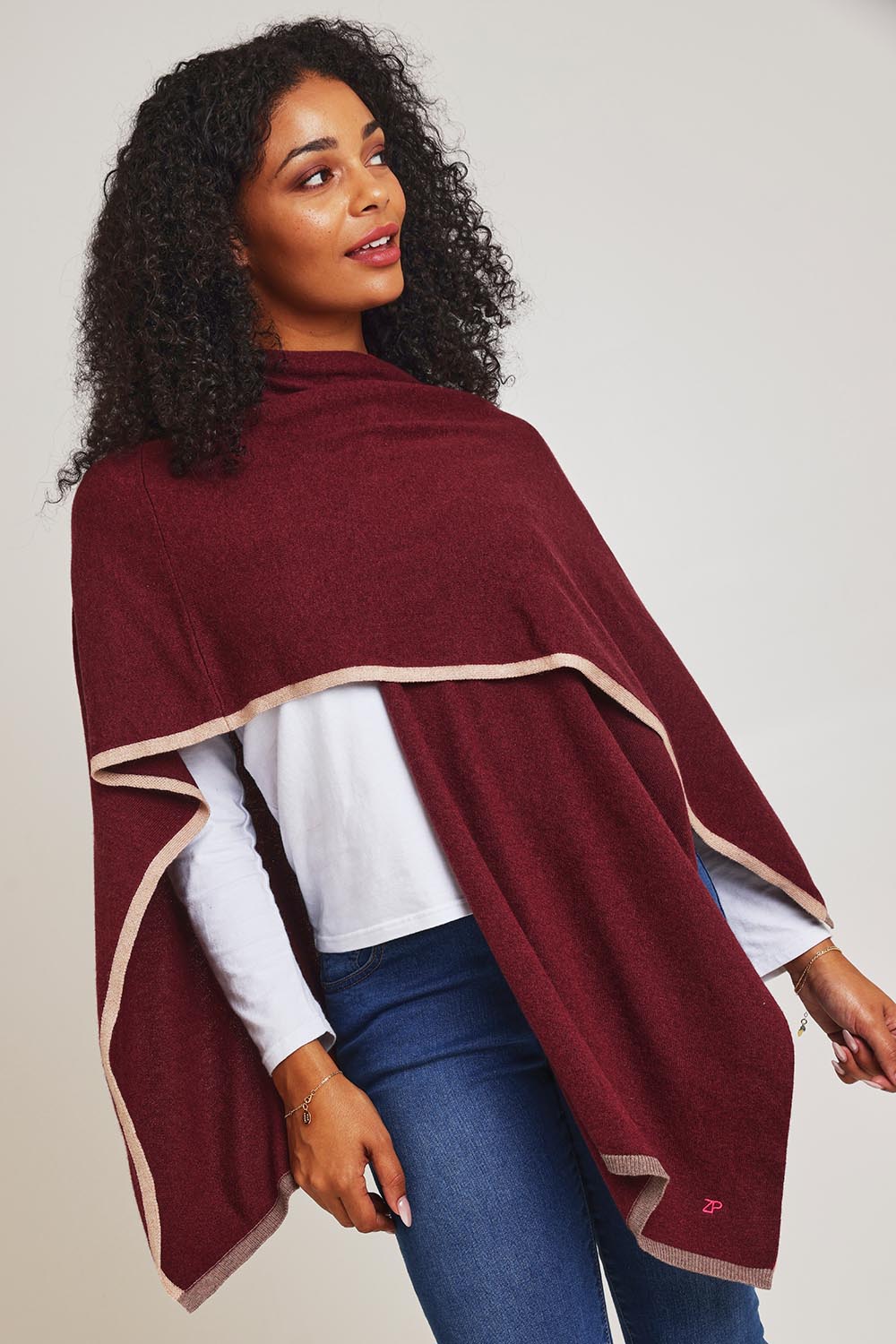 Model Ziara wearing the Cotton Cashmere Poncho in colour Shiraz, from the front, cropped image