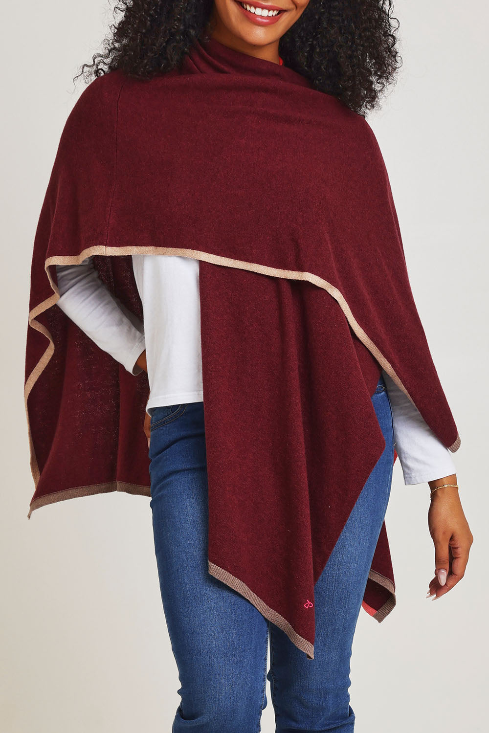 Model Ziara wearing the Cotton Cashmere Poncho in colour Shiraz, from the front, cropped image
