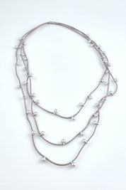 A model wearing the Emaline Multi Row Necklace in colour Silver (Metallics), from the front, showing the whole outfit