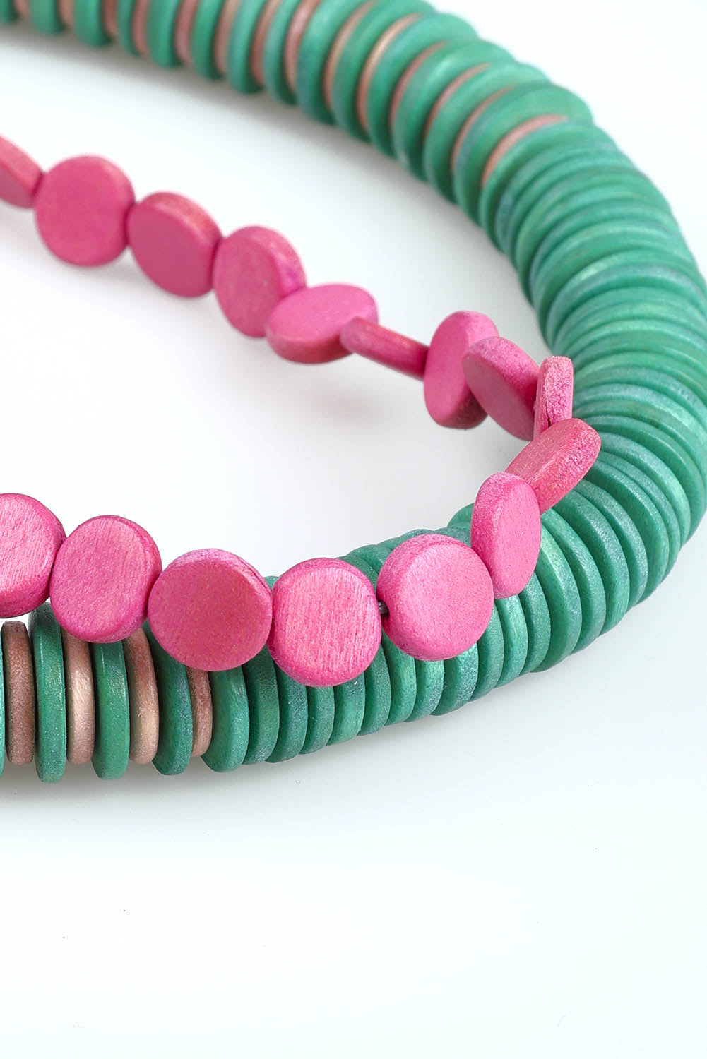 A model wearing the Laroda Wooden Necklace in colour Greenpink, from the front, showing the whole outfit