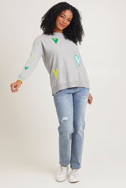 Model Ziara wearing size S of the Intarsia Hearts Cotton Cashmere Jumper in colour Marl (Grey), from the front, showing the whole outfit
